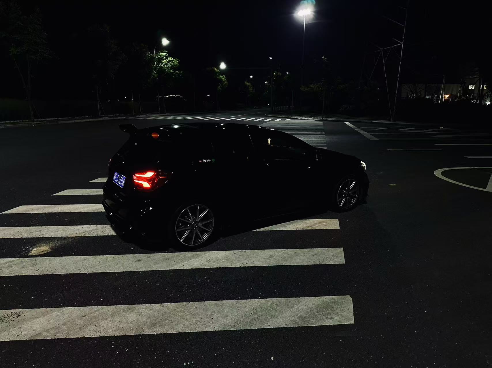 宽阔夜间路口中的黑色车辆